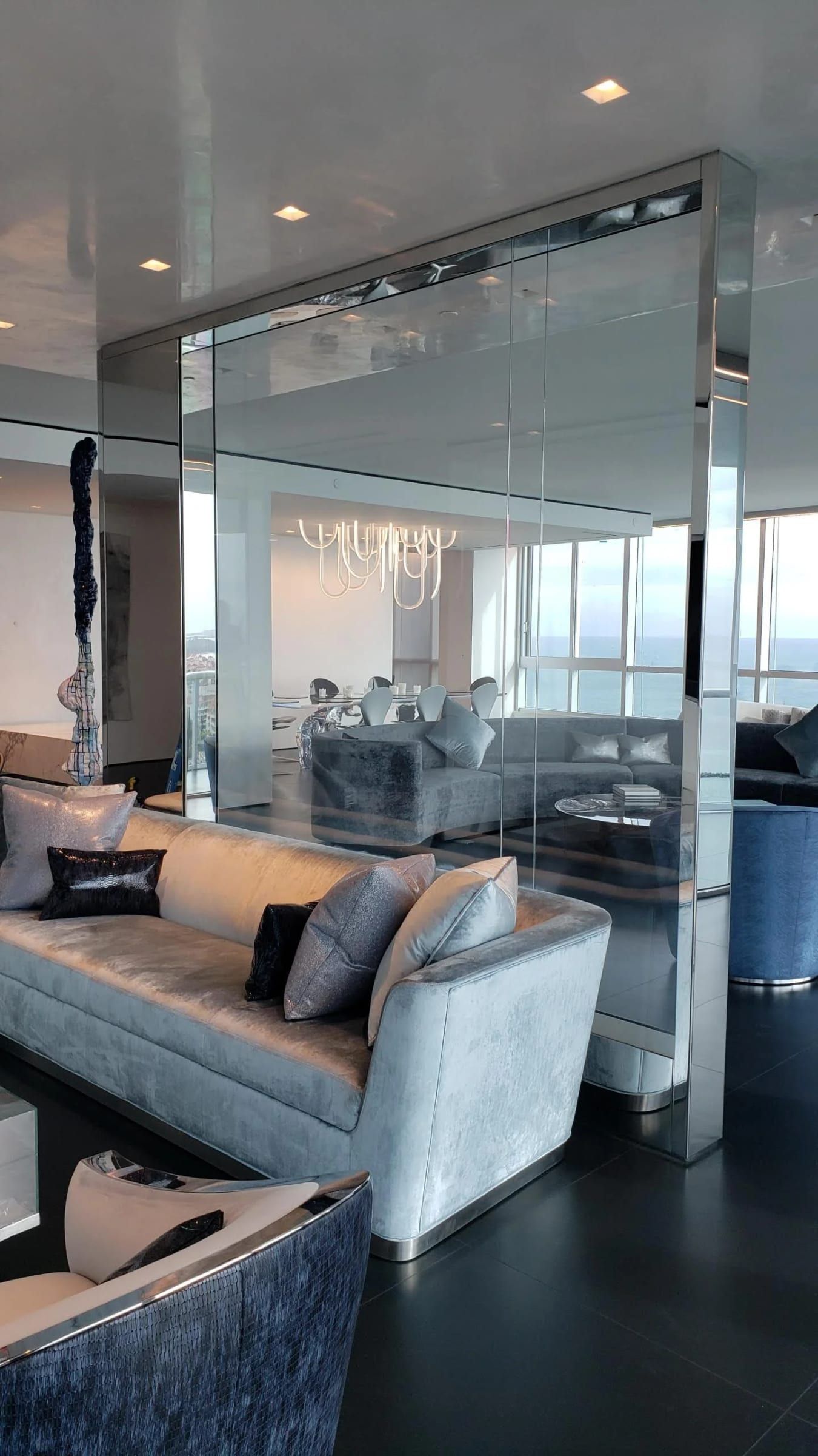 Glass partition with blackened stainless framing in a living room