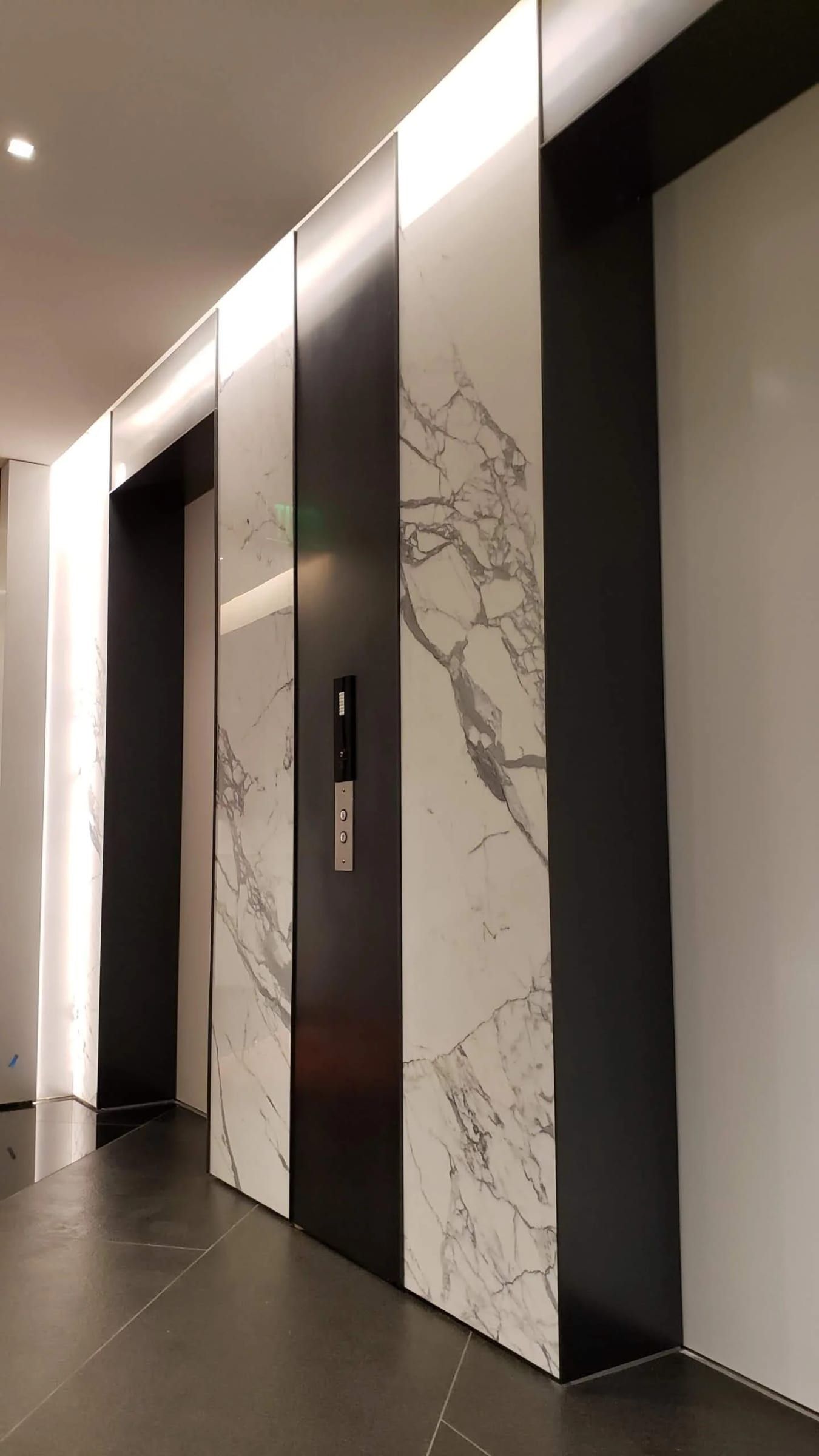 Blackened stainless surround beside marble cladding