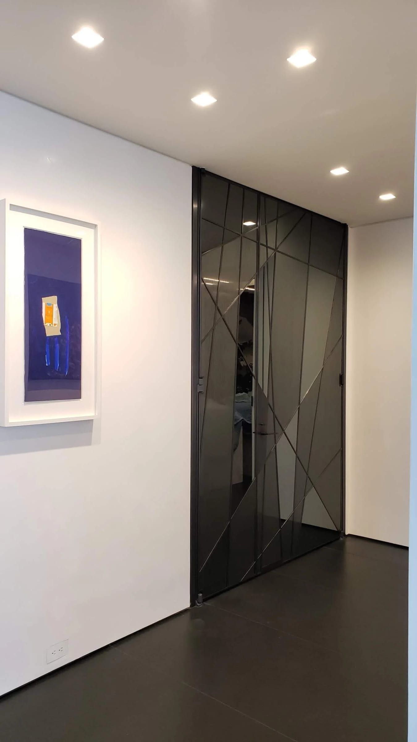 Blackened stainless glass door in a gallery hallway