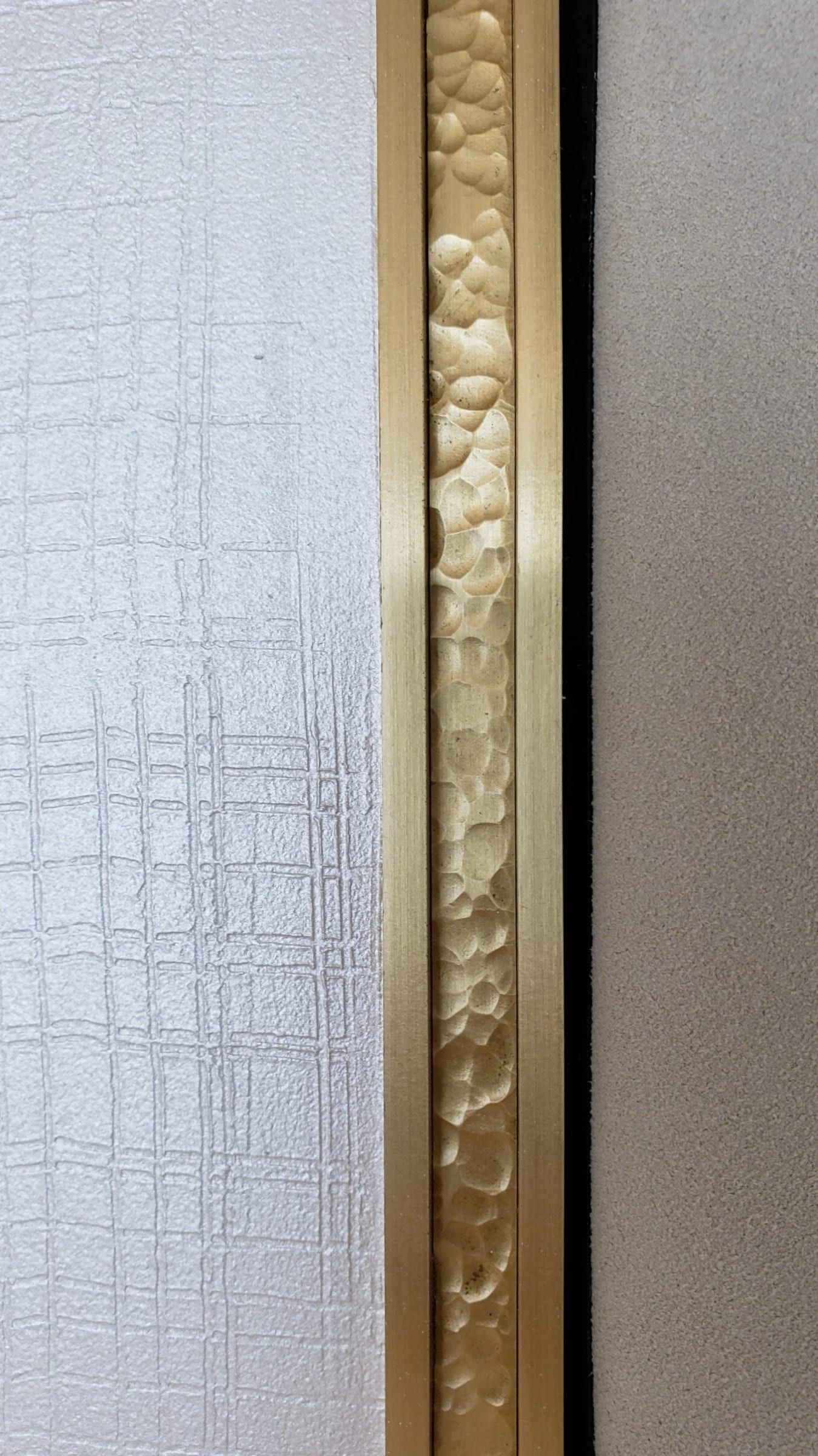 Brass trim against textured glass, close detail