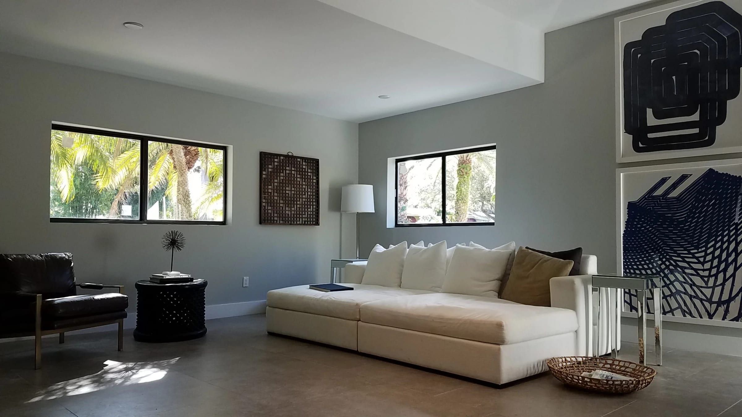 Renovated living room with a white sofa and large windows